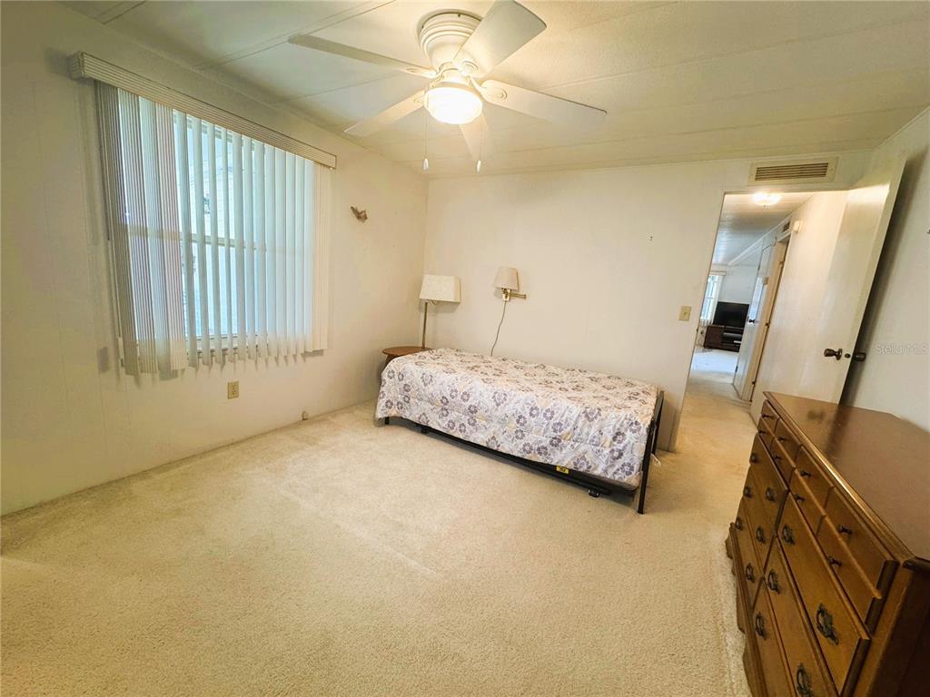 202 Aspen Circle Leesburg, FL 34748 - Photo 19 of 34 a bedroom with a bed dresser and a window