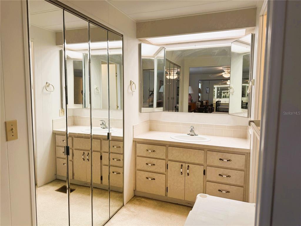 202 Aspen Circle Leesburg, FL 34748 - Photo 23 of 34 a bathroom with a double vanity sink and mirror