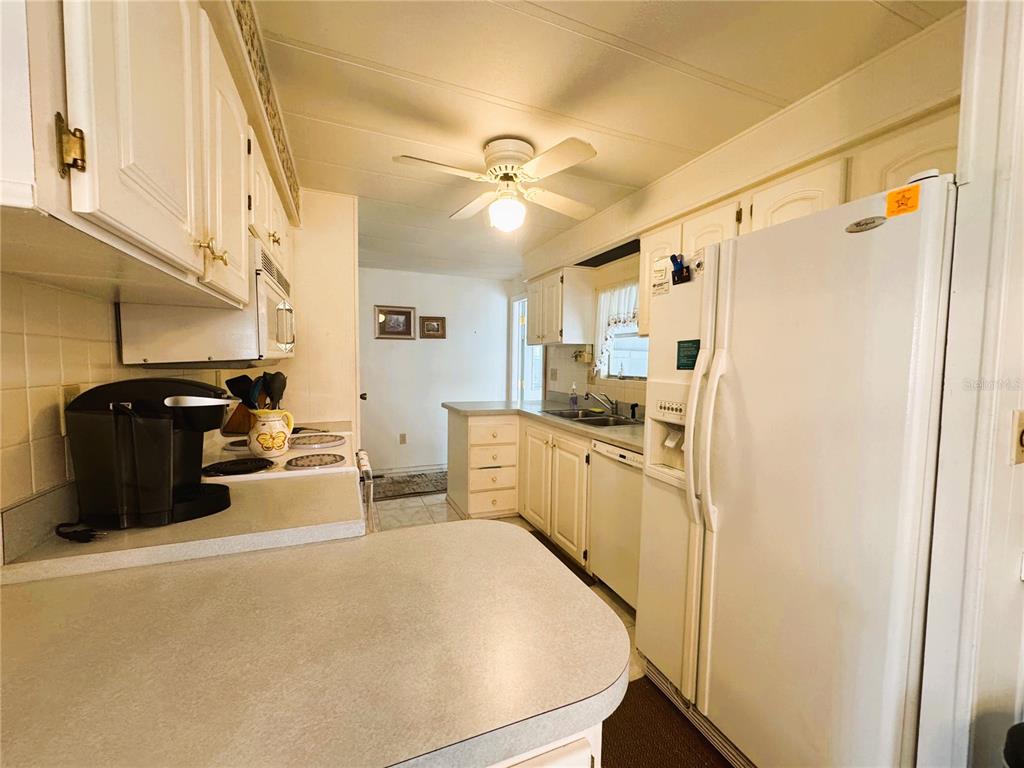 202 Aspen Circle Leesburg, FL 34748 - Photo 7 of 34 a kitchen with refrigerator and cabinets