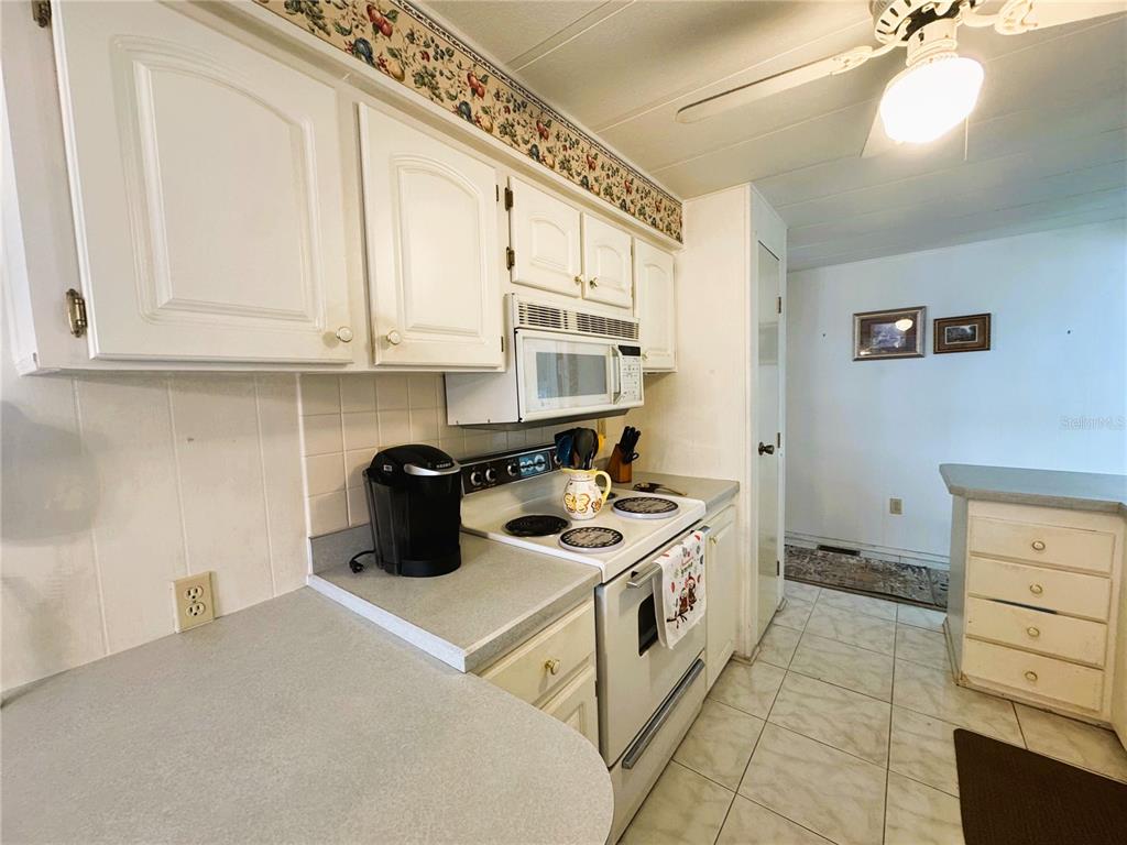 202 Aspen Circle Leesburg, FL 34748 - Photo 8 of 34 a kitchen with a stove and a white cabinets