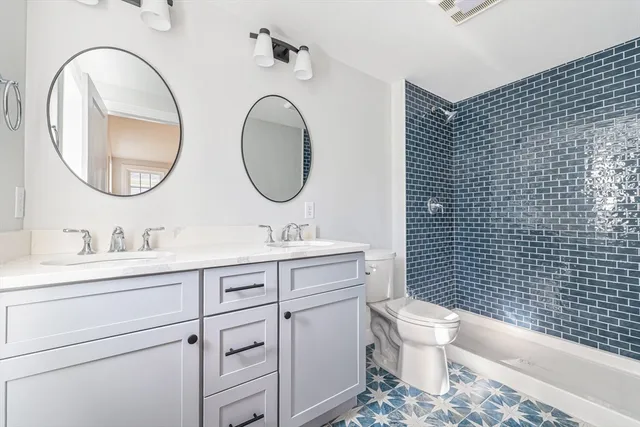 a bathroom with a toilet a sink a mirror and bathtub