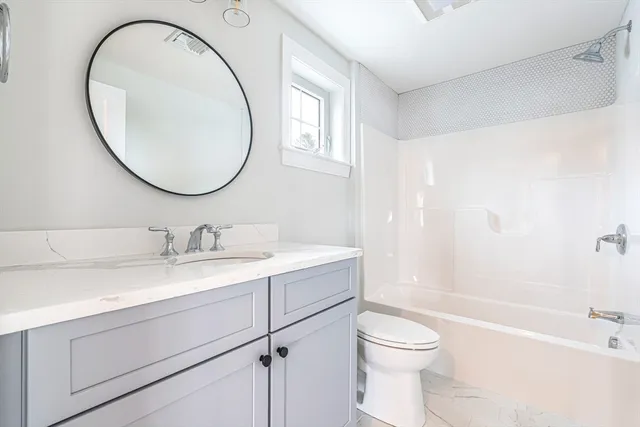 a bathroom with a sink a toilet and a mirror
