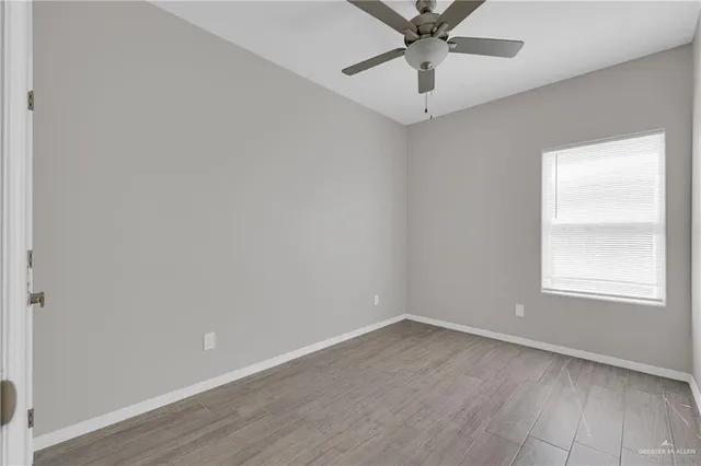 an empty room with a window and a fan