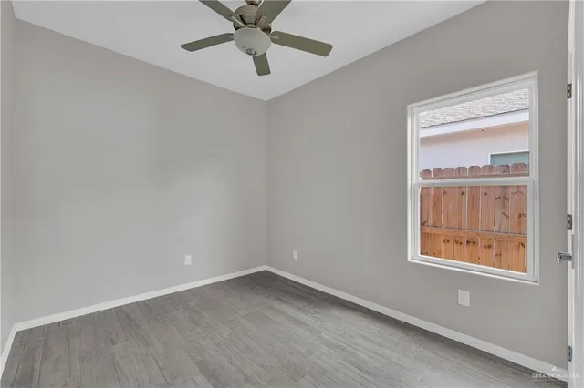 an empty room with a window and a fan