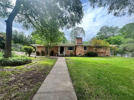 a front view of a house with a yard and potted plants