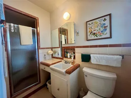 a bathroom with a toilet sink and mirror