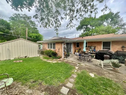 a view of a house with backyard sitting area and garden