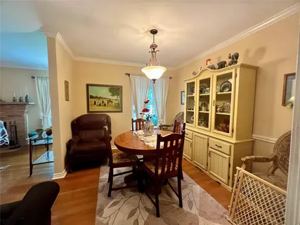 a dining room with furniture a chandelier and wooden floor