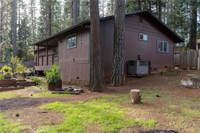 a view of a backyard with large tree and wooden fence