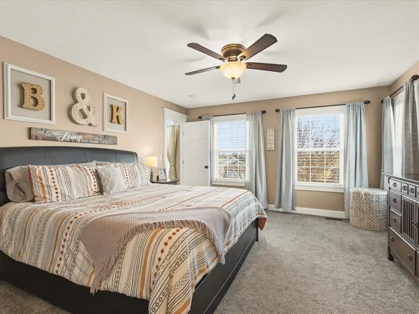 a bedroom with a workspace and a large window