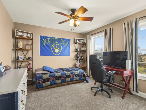 a bedroom with a chair and a flat screen tv