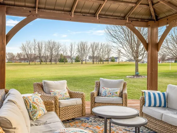 a view of swimming pool with outdoor seating and house in the background