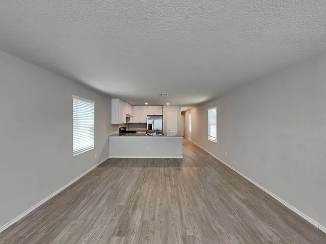 a view of a kitchen with wooden floor and windows