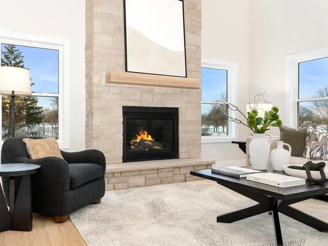 a living room with furniture a fireplace and a floor to ceiling window