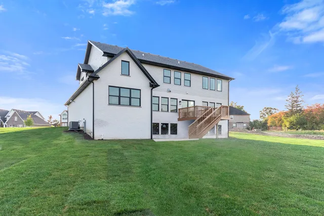 a view of a house with a big yard and large trees