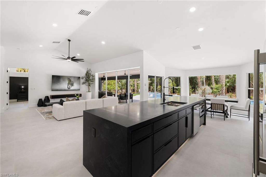 4521 3rd Avenue Northwest Naples, FL 34119 - Photo 10 of 46 a kitchen with counter top space a sink appliances and living room view