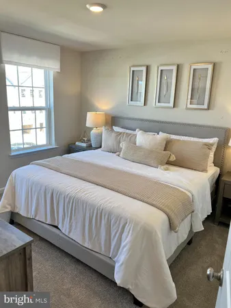 a large bed sitting in a bedroom next to a window