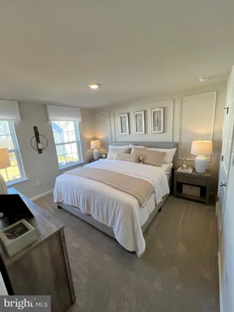 a spacious bedroom with a bed a couch and a dresser next to a window