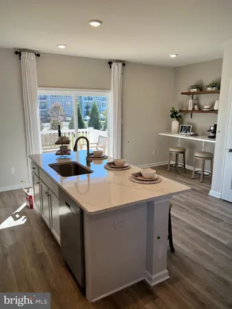 a kitchen with kitchen island a sink stove and wooden floor