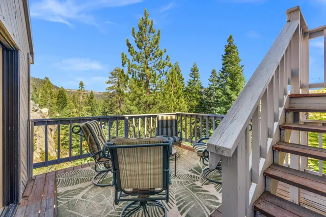 a balcony with wooden floor table and chairs