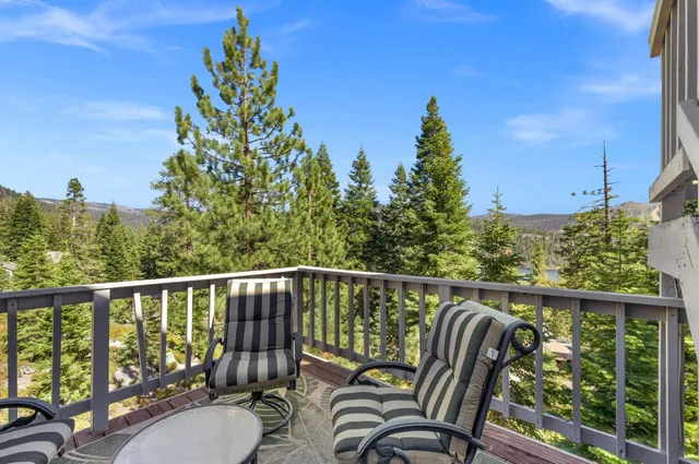 a balcony with wooden floor and outdoor seating