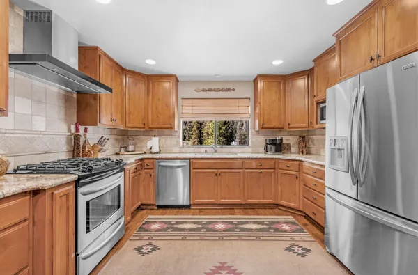 a kitchen with stainless steel appliances granite countertop a refrigerator sink and stove
