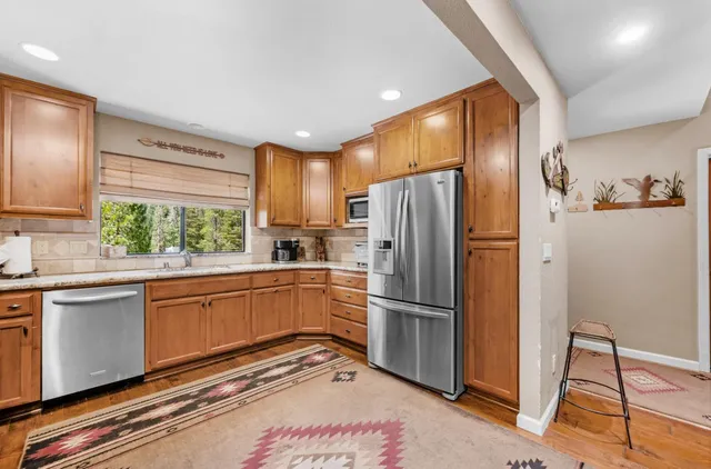 a kitchen with stainless steel appliances granite countertop a refrigerator and a sink