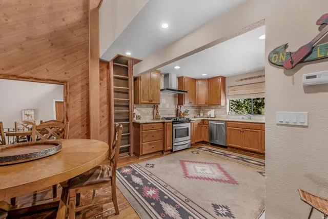 a kitchen with stainless steel appliances kitchen island granite countertop a stove a sink and a refrigerator