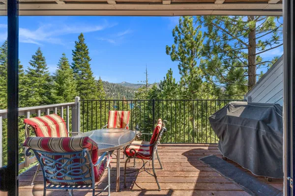 a balcony with wooden floor table and chairs
