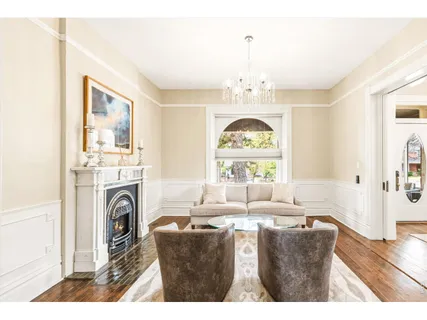 a living room with furniture a fireplace and a chandelier