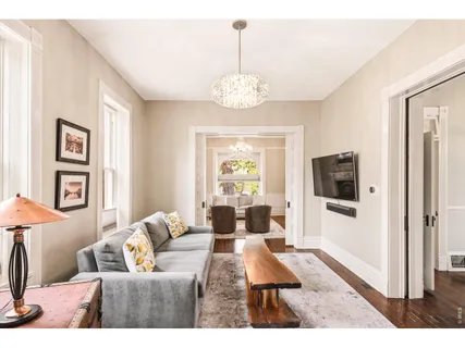 a living room with furniture a flat screen tv and a window