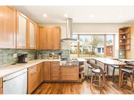 a kitchen with a stove a refrigerator and wooden cabinets