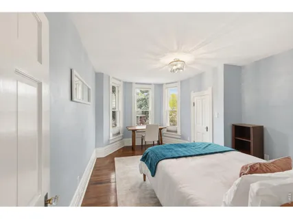 a bedroom with a large bed and a chandelier