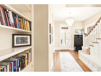 a view of a hallway with wooden floor and windows