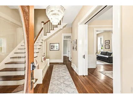 a view of a hallway with wooden floor and staircase
