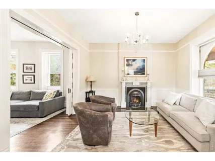 a living room with furniture a chandelier and a fireplace