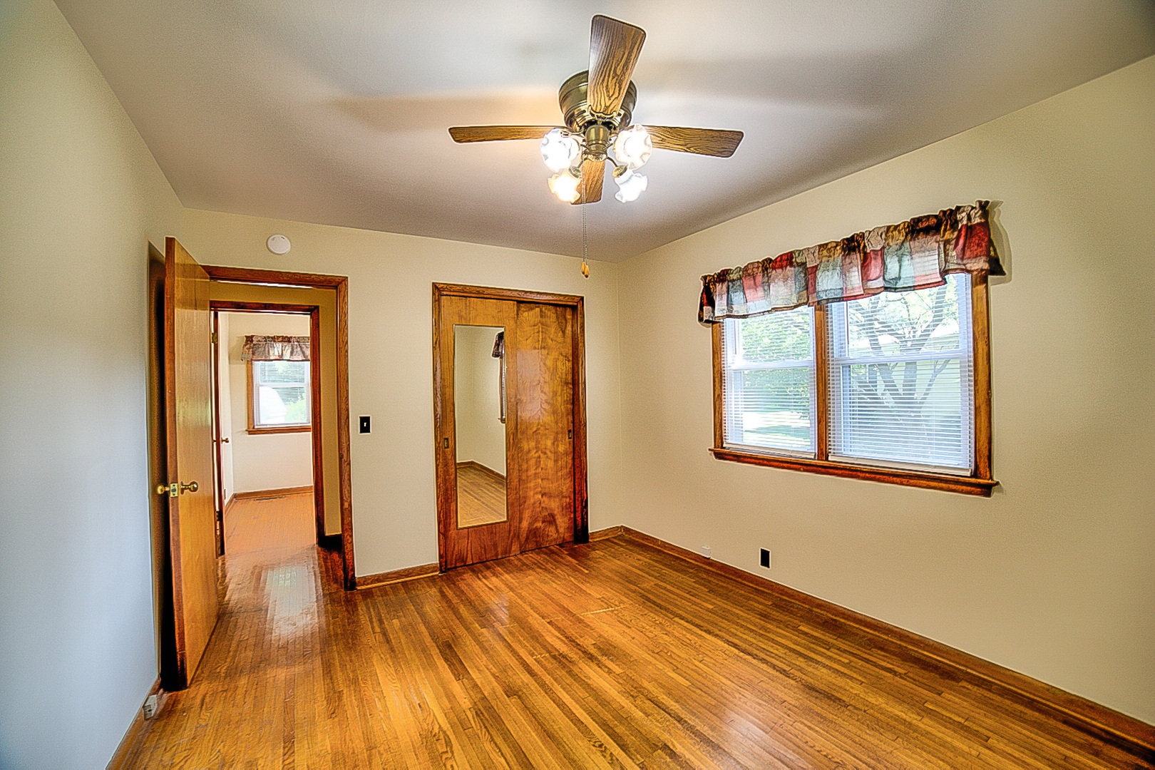 912 East Locust Street Watseka, IL 60970 - Photo 13 of 18 a view of an empty room with a window and wooden floor
