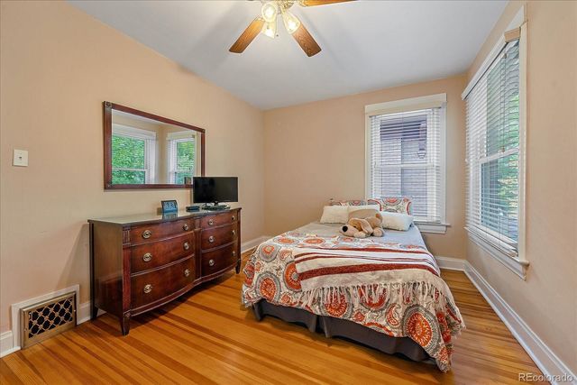 a bedroom with a bed and a flat tv screen on dresser