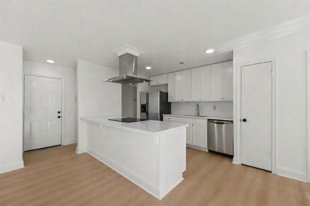 5516 Maple Lane Rowlett, TX 75089 - Photo 8 of 18 a kitchen that has a lot of white cabinets and stainless steel appliances