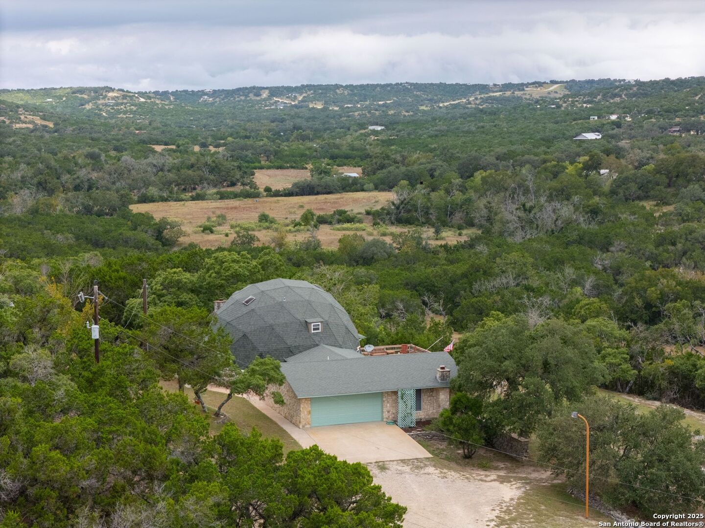 a aerial view of a house with a yard and lake view