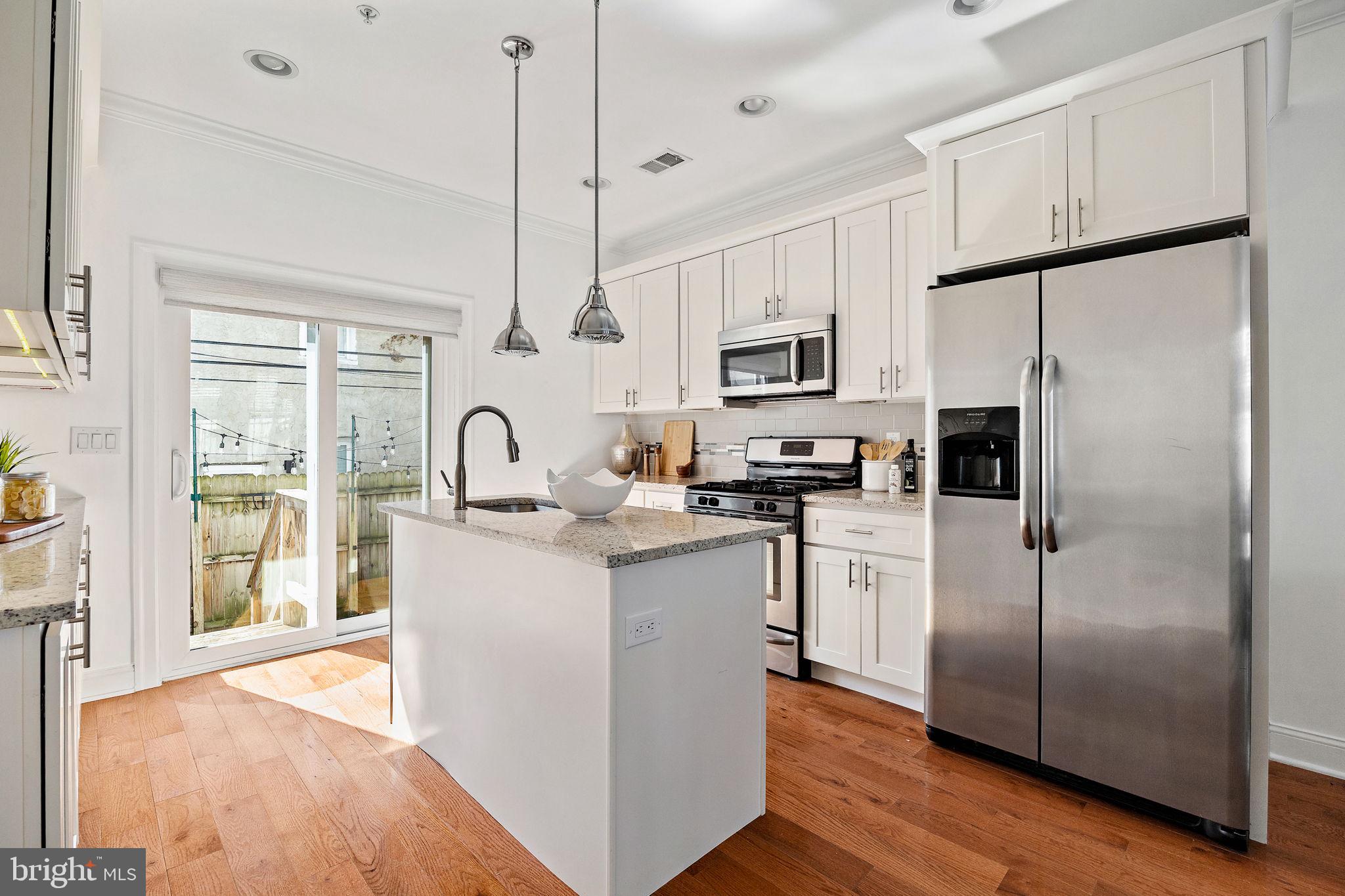432 Mercy Street Philadelphia, PA 19148 - Photo 11 of 36 a kitchen with white cabinets and stainless steel appliances