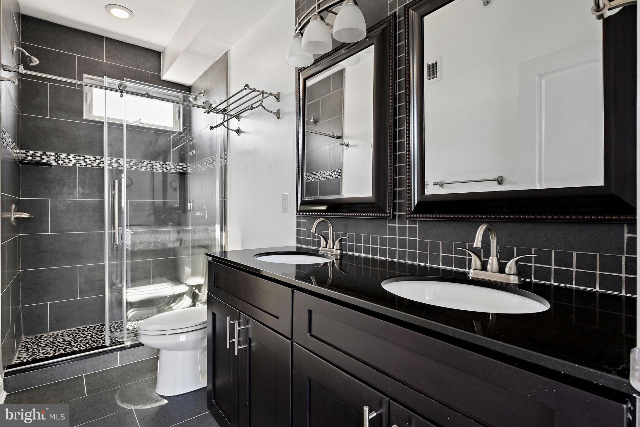432 Mercy Street Philadelphia, PA 19148 - Photo 25 of 36 a bathroom with a granite countertop sink a toilet and shower