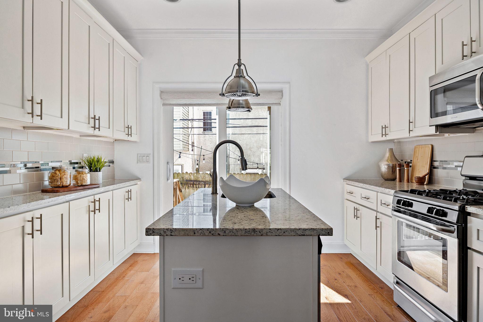 432 Mercy Street Philadelphia, PA 19148 - Photo 7 of 36 a kitchen with granite countertop white cabinets and stainless steel appliances
