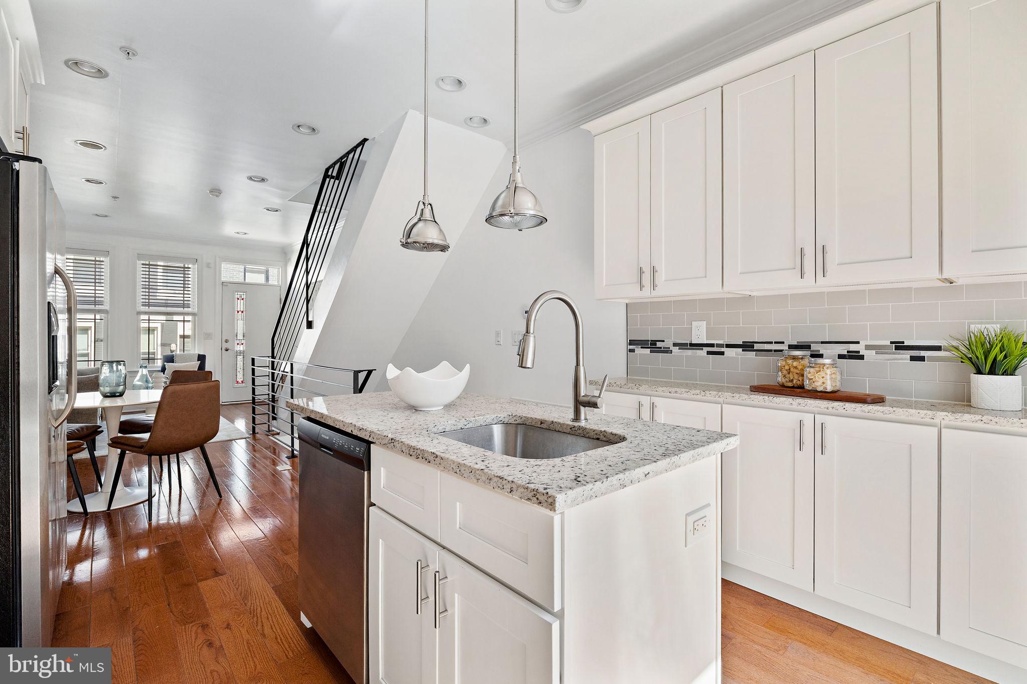 432 Mercy Street Philadelphia, PA 19148 - Photo 8 of 36 a kitchen with stainless steel appliances granite countertop a sink dishwasher and white cabinets with wooden floor