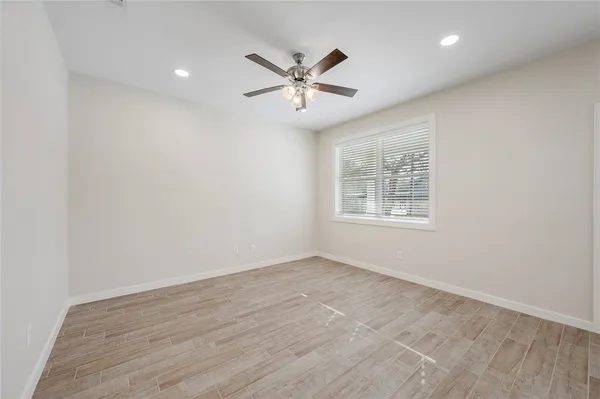 an empty room with window and ceiling fan