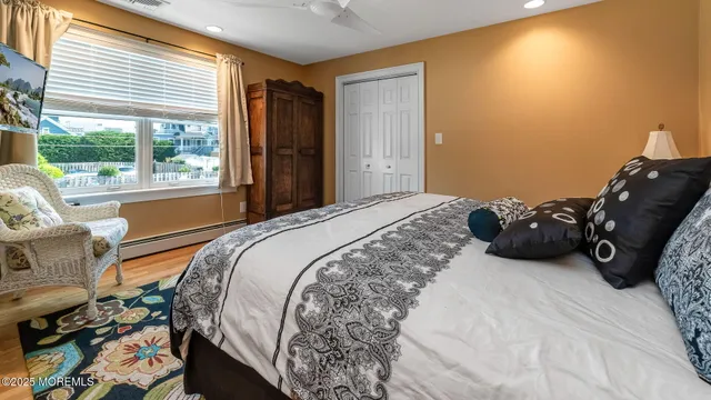 a bedroom with a bed a chair and a large window