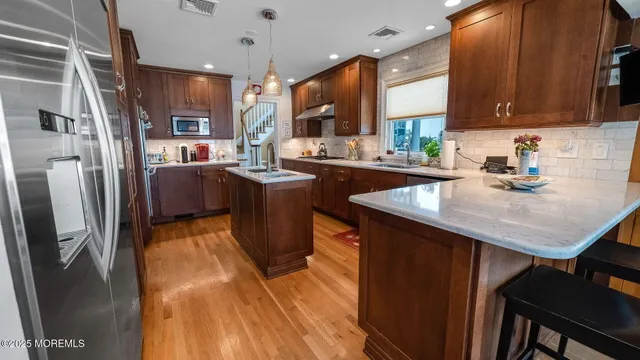 a kitchen with stainless steel appliances granite countertop a sink refrigerator and cabinets