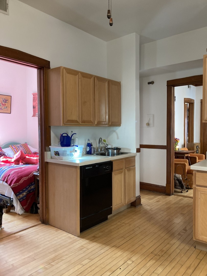 2223 West Iowa Street, Unit 2R Chicago, IL 60622 - Photo 11 of 20 a kitchen with granite countertop a sink cabinets and wooden floor