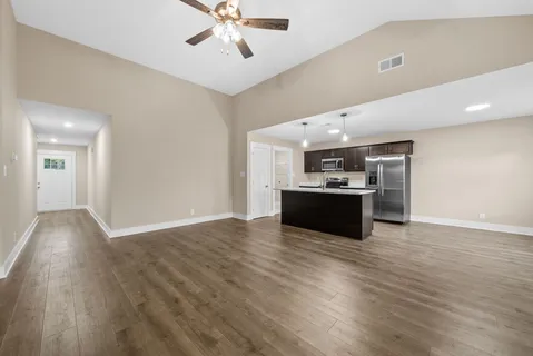 a view of a kitchen with a sink oven cabinets and wooden floor