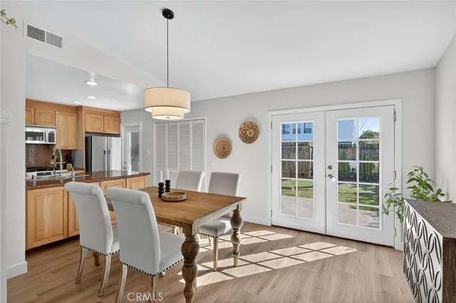 a dining room with furniture a chandelier and wooden floor